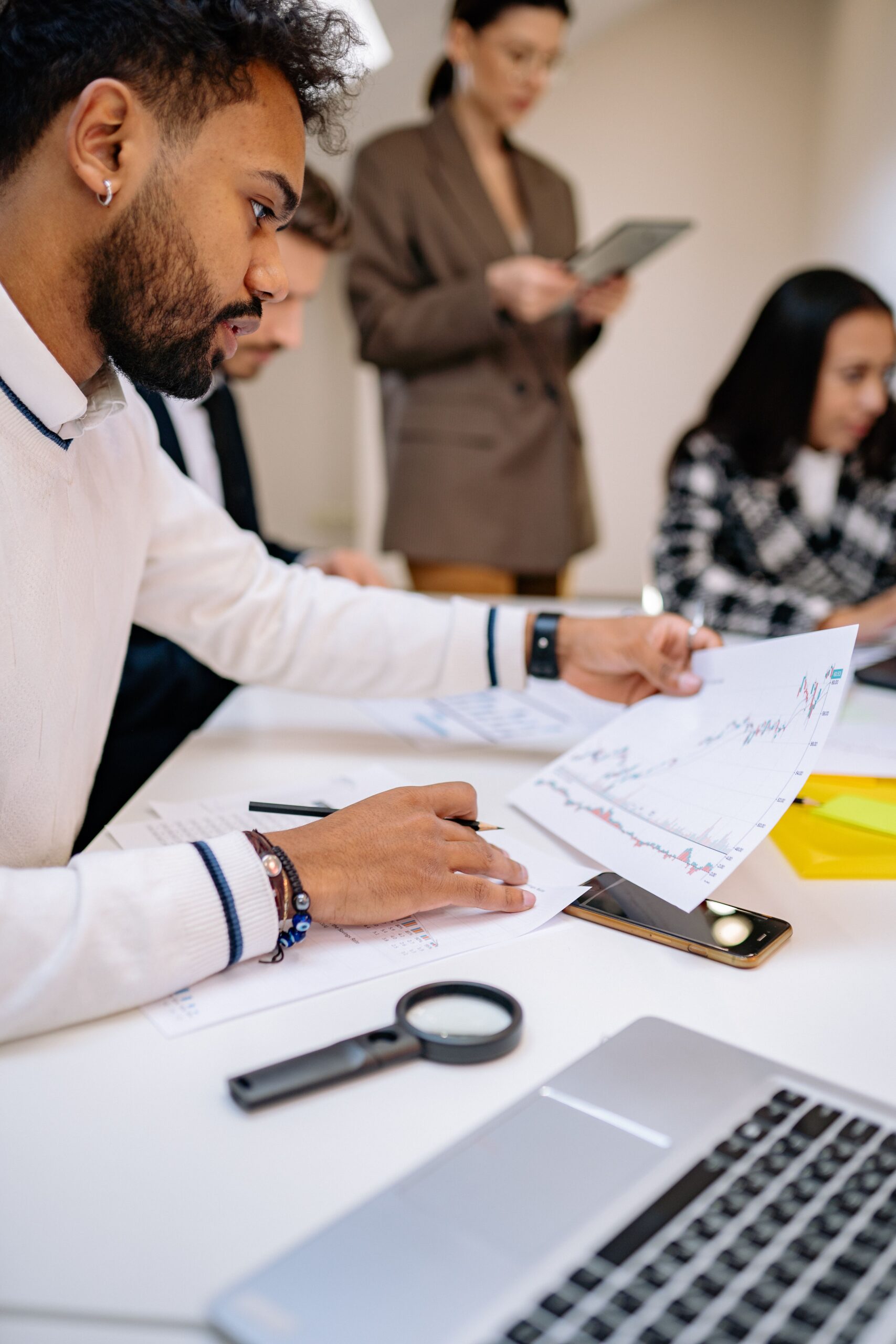 Focused professionals analyzing documents in a collaborative business meeting setting.